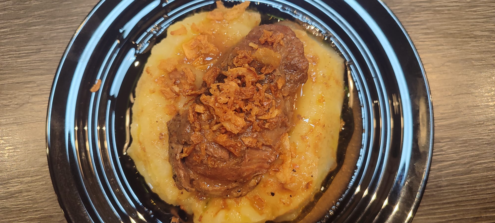 Carrillera de porco con crema fina de patata y zanahoria y aceite de trufa